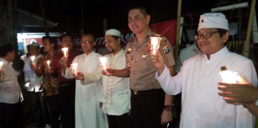 Sejumlah warga masyarakat dan Kapolres Jember AKBP Alfian Nurrizal Aliansi Cinta Damai saat aksi menyalakan seribu lilin di Depan Kantor DPRD Jember. (Kj)