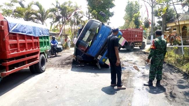 AMBRUK : Kondisi Dump Truk yang terguling di tengah jalan raya. (rir)