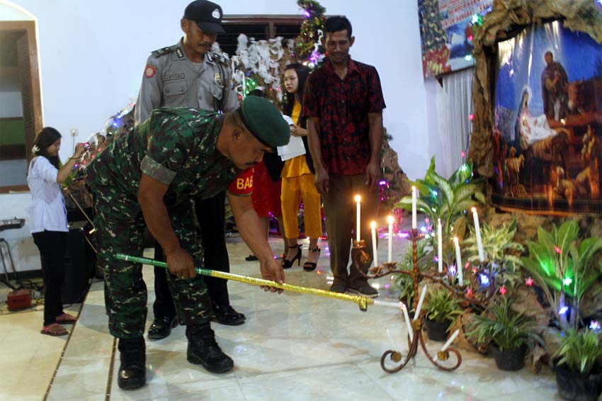 Babinsa M. Kosim sedang menyalakan Lilin di dampingi Babinkamtibmas dan Tokoh masyarakat. (tog)