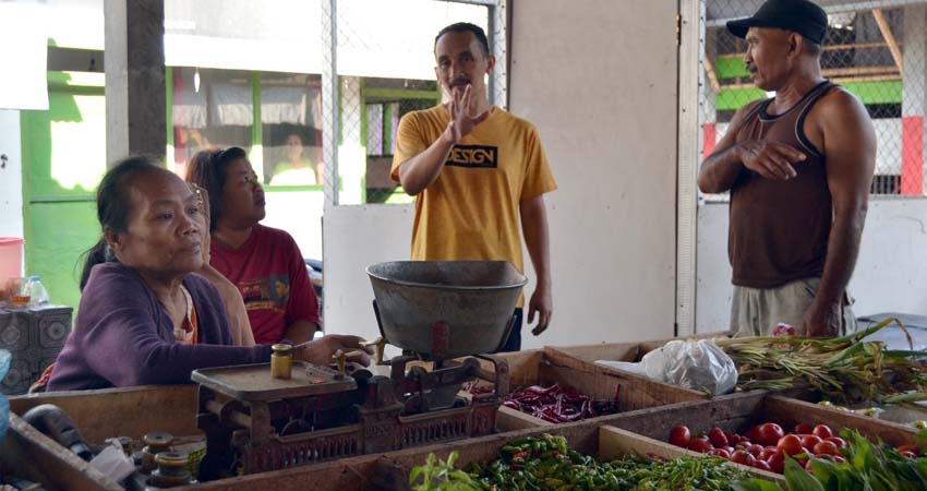 Syamsul Arifin (baju kuning) beriteraksi dengan pedagang di pasar. (yud)