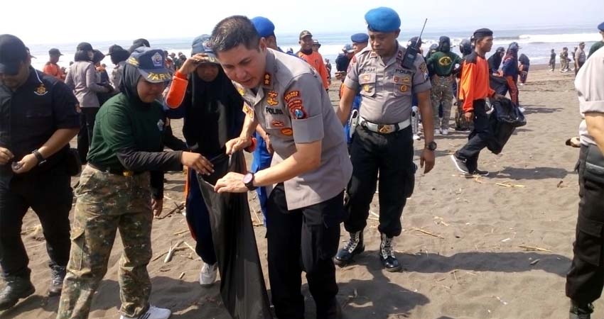 Kapolres Jember bersama relawan memungut sampah limbah plastik di Pantai Pancer. (ist)