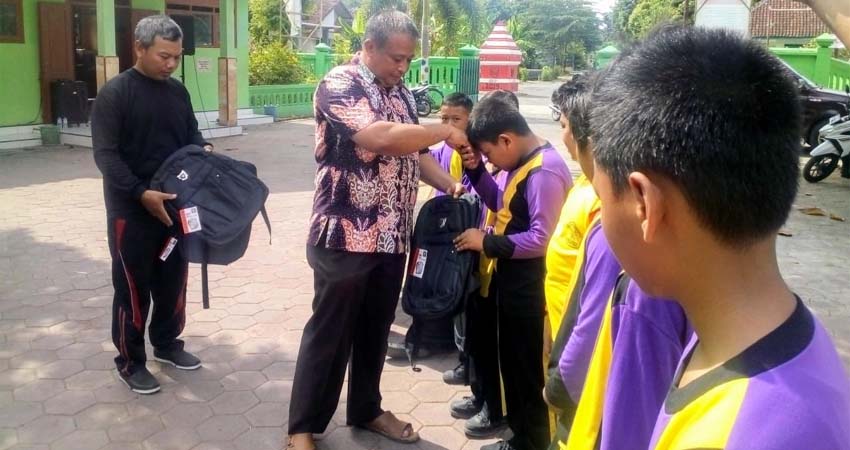 Anggota DPRD Kabupaten Jember Nurhasan, serahkan langsung tas sekolah kepada puluhan siswa di SD 02 Keting. (ist)