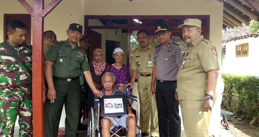 Pak Salim dengan kursi rodanya, menerima rombongan Muspika Kecamatan Patrang. (gik)