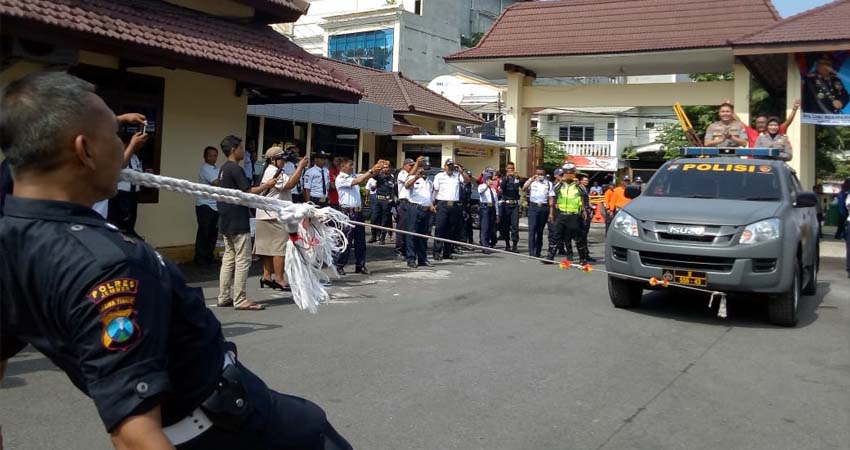 Kapolres Jember berada diatas mobil, ditarik dengan tali yang melekat ke giginya. (ist)